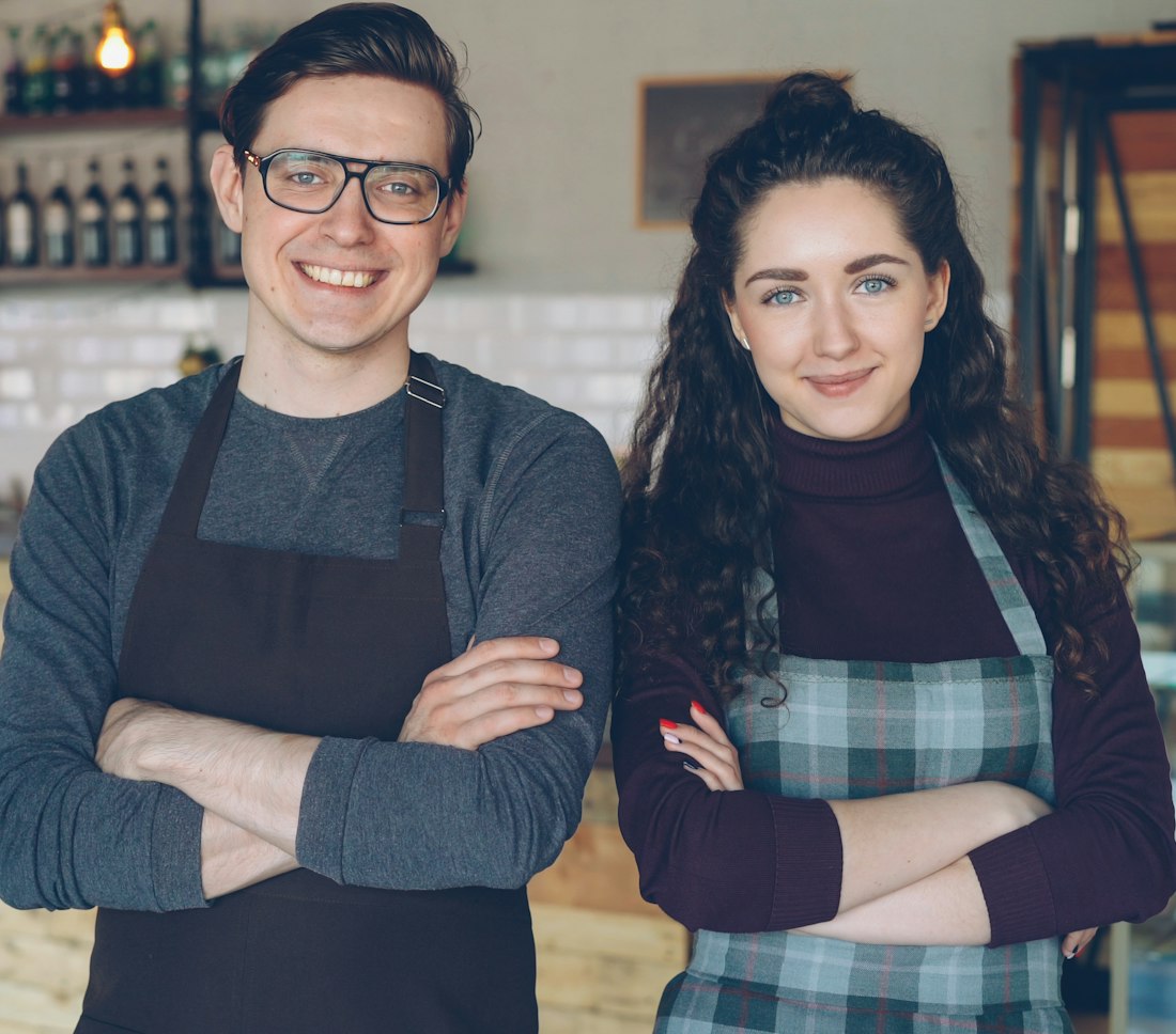 Two cafe owners stand together