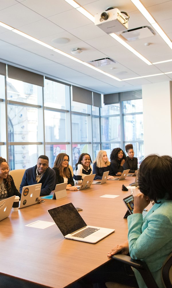 Group at a wooden table with laptops