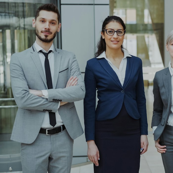 Four business professionals stand together